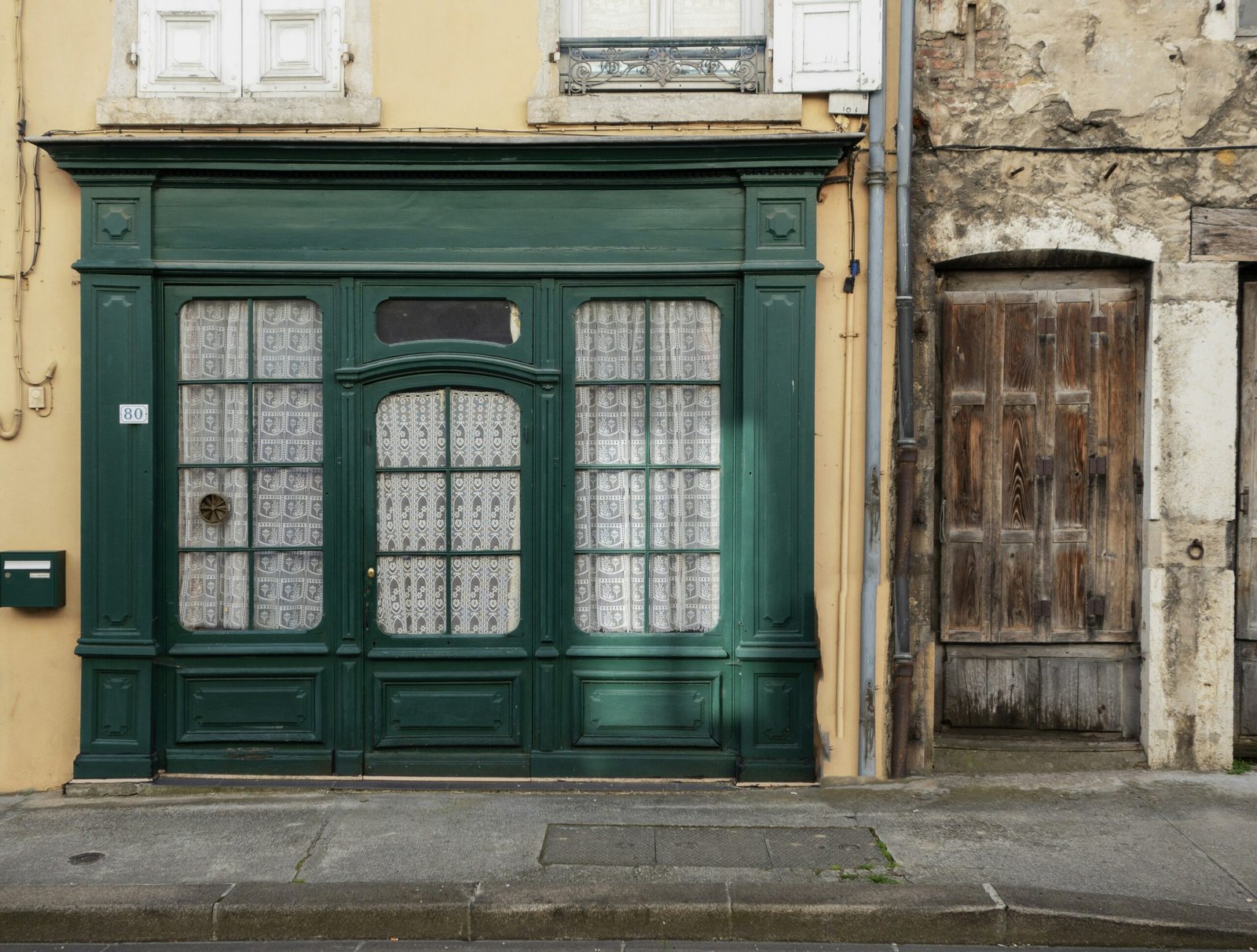 an old building with a green door and window